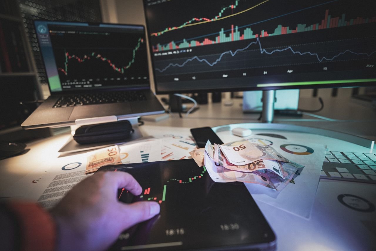 A modern trading desk with screens showing market charts and euro notes, capturing a trading atmosphere.